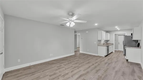 a view of kitchen center island wooden floor and ceiling fan
