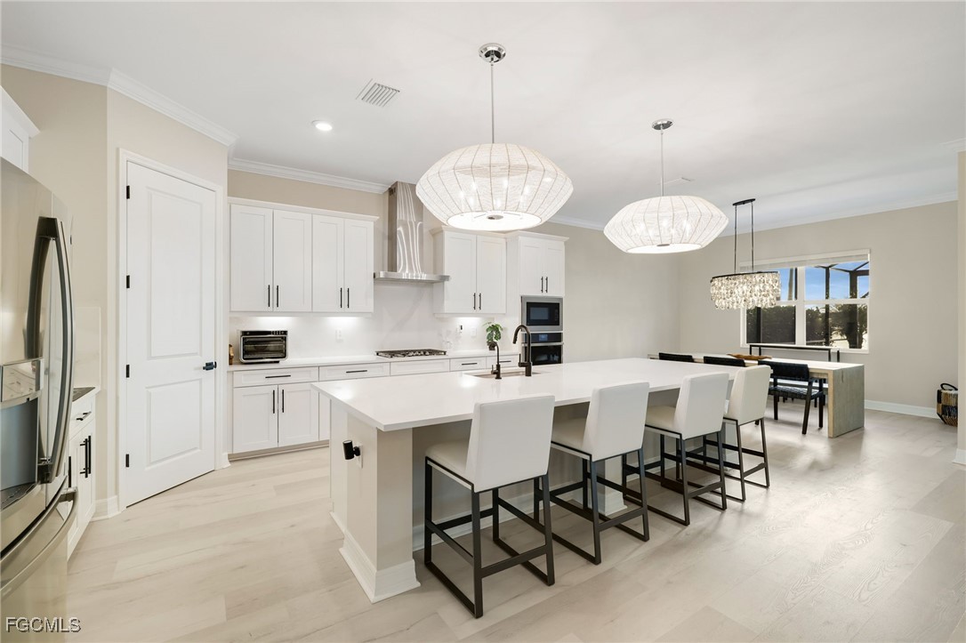 13670 Blue Bay Circle Fort Myers, FL 33913 - Photo 6 of 50 a kitchen with stainless steel appliances a table chairs sink and cabinets