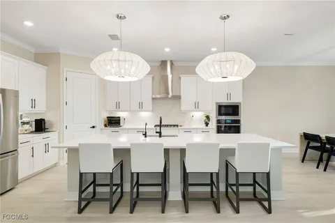 a kitchen with stainless steel appliances a dining table chairs and a chandelier