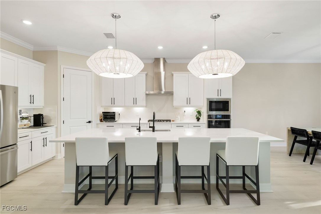 13670 Blue Bay Circle Fort Myers, FL 33913 - Photo 7 of 50 a kitchen with stainless steel appliances a dining table chairs and a chandelier
