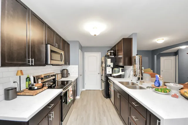 a kitchen with stainless steel appliances a stove sink microwave and cabinets
