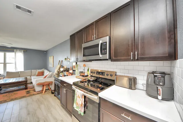 a kitchen with stainless steel appliances a sink stove and microwave