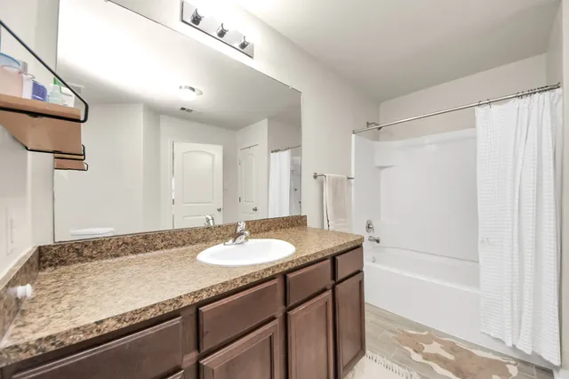 a bathroom with a granite countertop sink a toilet and bathtub