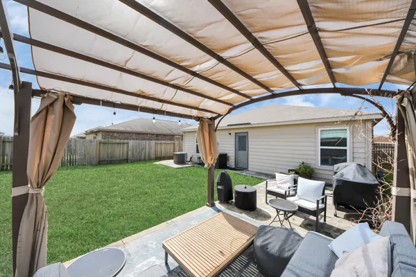 a view of a backyard with couches plants and large tree