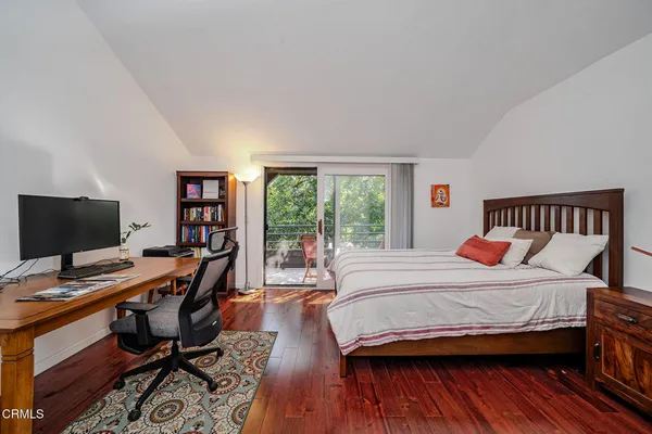 a bedroom with a bed and a computer on a desk