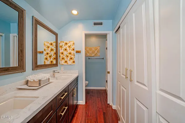 a bathroom with a granite countertop sink a mirror a vanity and shower