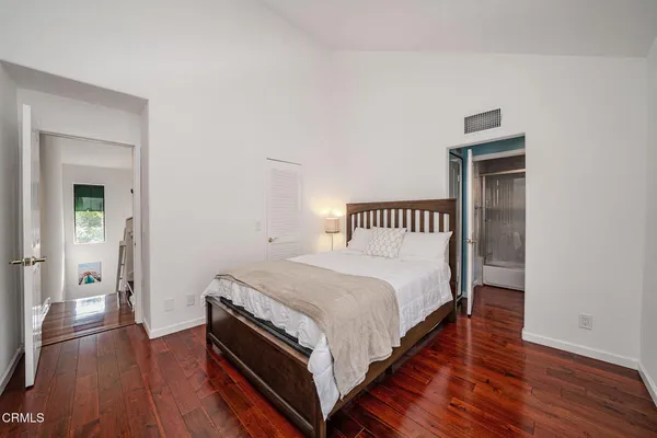 a bedroom with a bed and wooden floor
