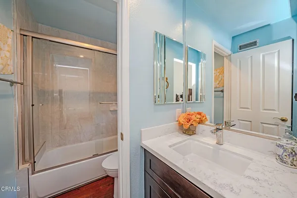 a bathroom with a granite countertop sink a toilet and shower