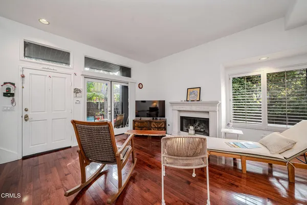 a living room with furniture a fireplace and a floor to ceiling window
