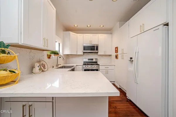 a kitchen with a refrigerator a stove and a cabinets