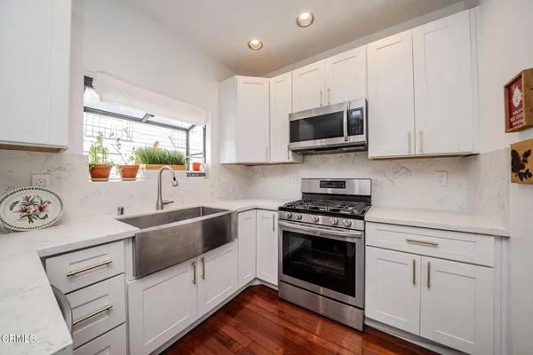 a kitchen with white cabinets and appliances