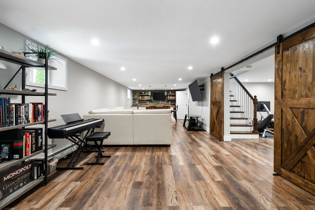 10 Marie Avenue Stoneham, MA 02180 - Photo 23 of 41 a living room with furniture a flat screen tv and a book shelf