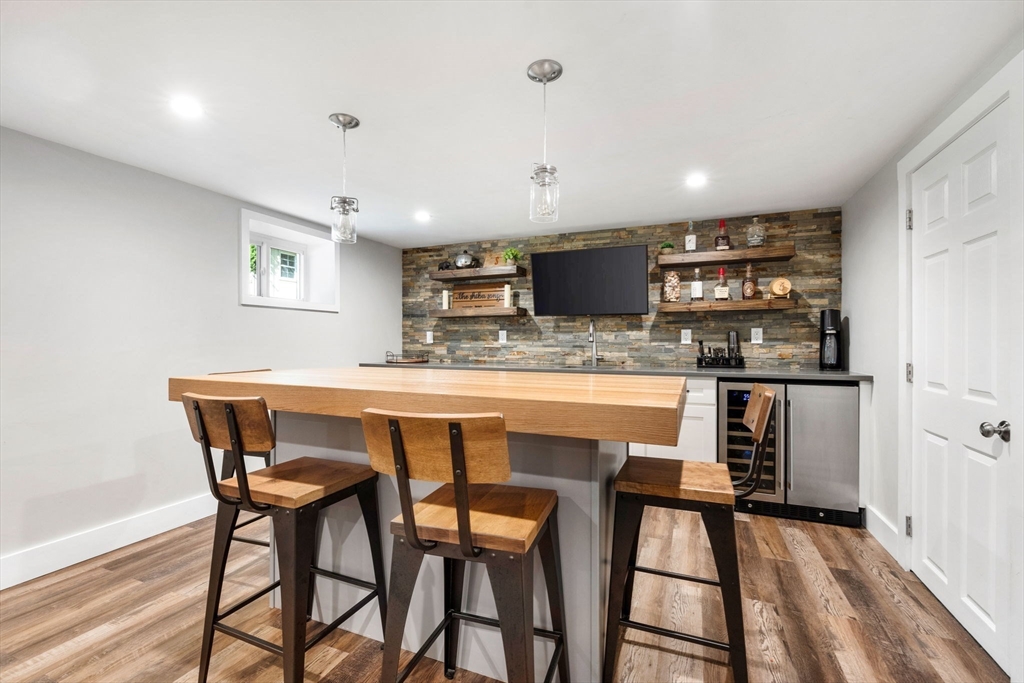 10 Marie Avenue Stoneham, MA 02180 - Photo 27 of 41 a kitchen with stainless steel appliances kitchen island granite countertop a dining table chairs and a refrigerator