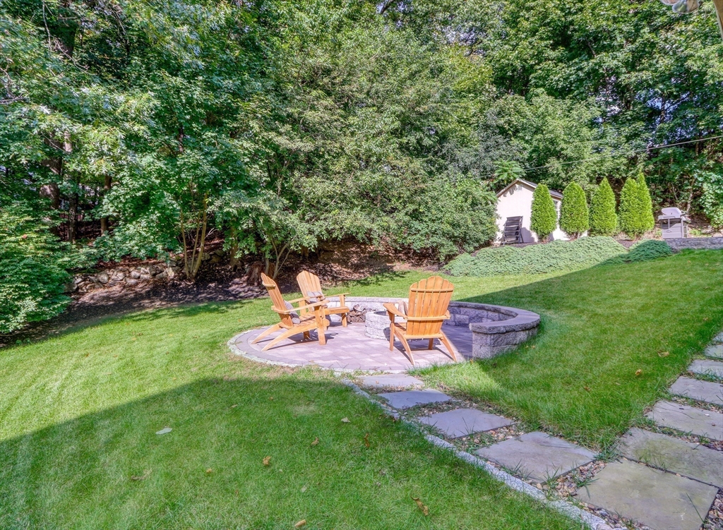 10 Marie Avenue Stoneham, MA 02180 - Photo 37 of 41 a view of a backyard with table and chairs and potted plants and large trees