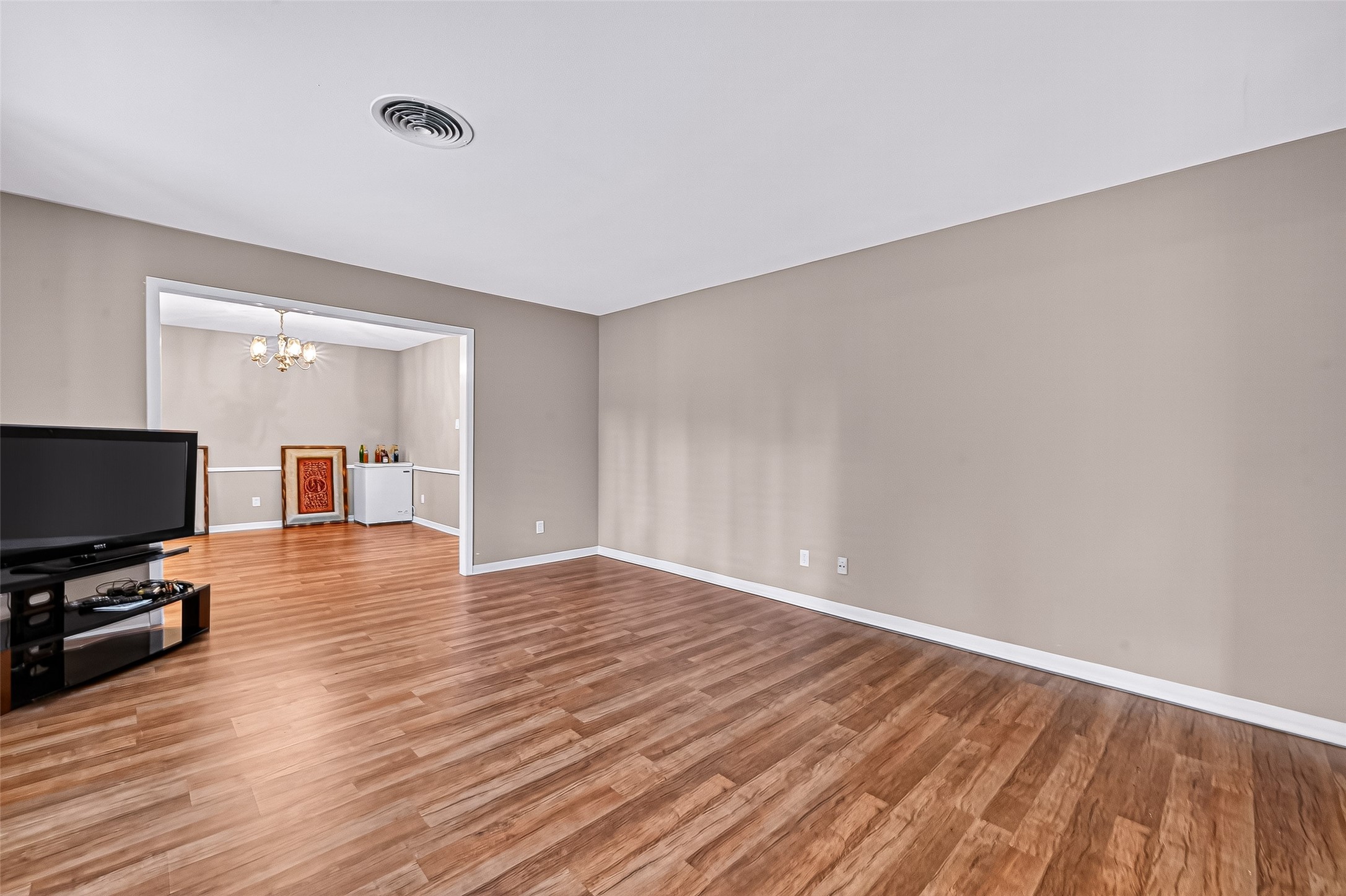 5734 Sanford Road Houston, TX 77096 - Photo 19 of 48 a view of empty room with wooden floor and a flat screen tv