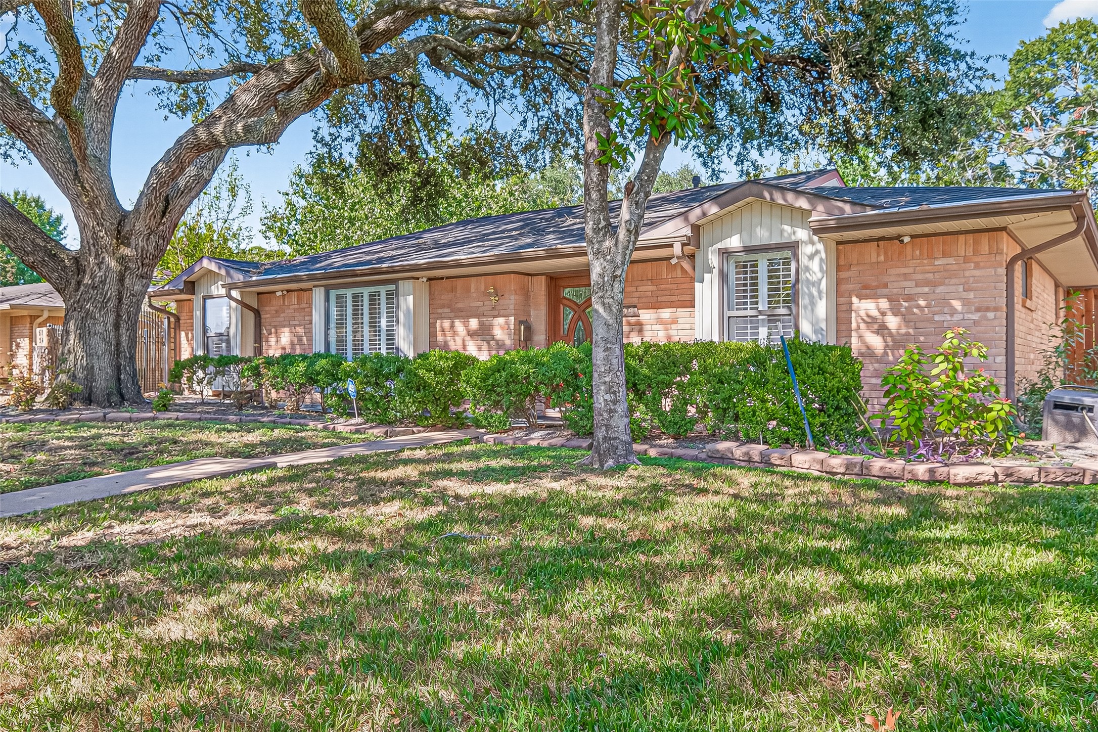 5734 Sanford Road Houston, TX 77096 - Photo 46 of 48 a front view of a house with a garden and trees