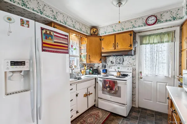 a kitchen with white cabinets and white appliances