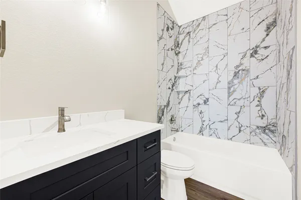 a bathroom with a sink a toilet and bathtub