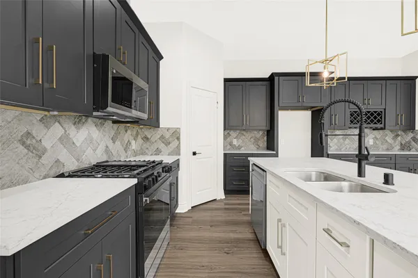 a kitchen with stainless steel appliances granite countertop a sink stove and microwave