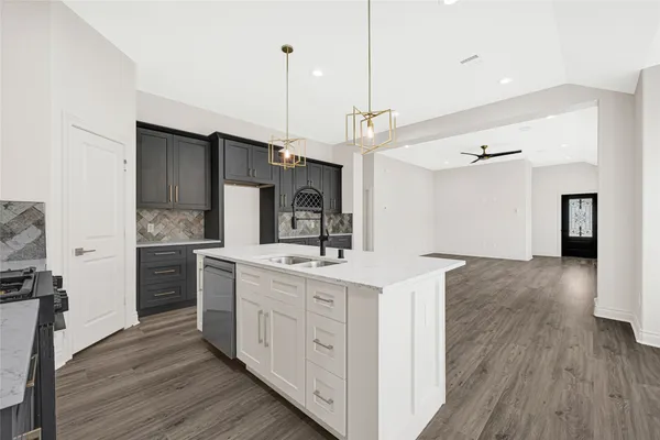 a kitchen with a sink a counter top space stainless steel appliances and wooden floor