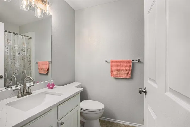 a bathroom with a sink vanity mirror and toilet