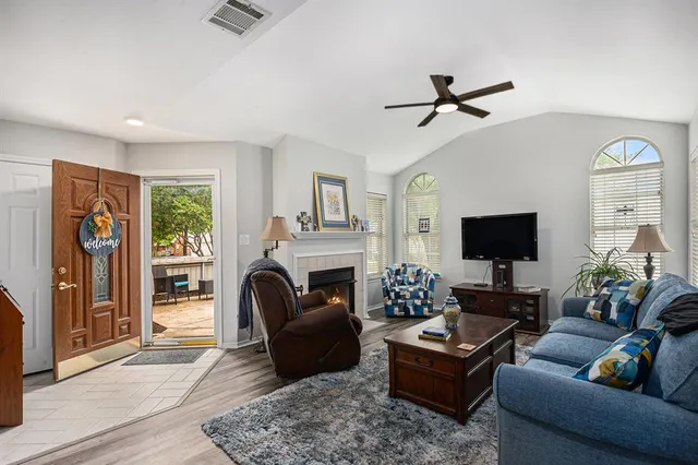 a living room with furniture a flat screen tv and a fireplace