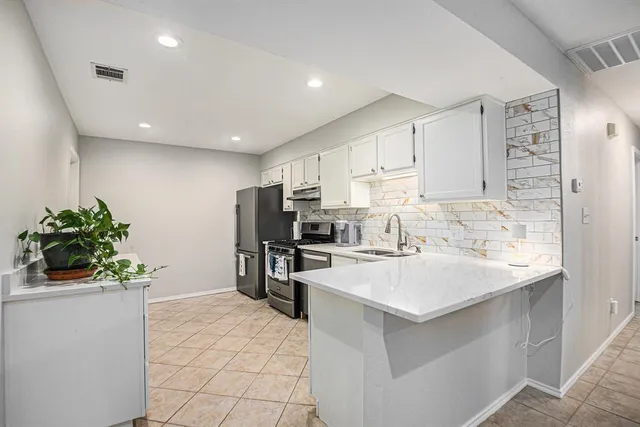 a kitchen with a sink a refrigerator and a stove top oven