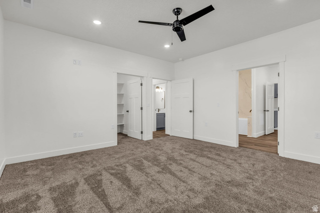 520 East 450th Street North Delta, UT 84624 - Photo 19 of 48 Unfurnished bedroom with a walk in closet, dark colored carpet, a ceiling fan, and recessed lighting
