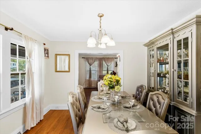 a dining room with furniture a livingroom view and wooden floor