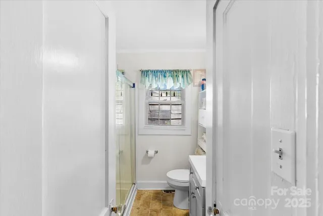 a bathroom with a granite countertop toilet a sink and a shower