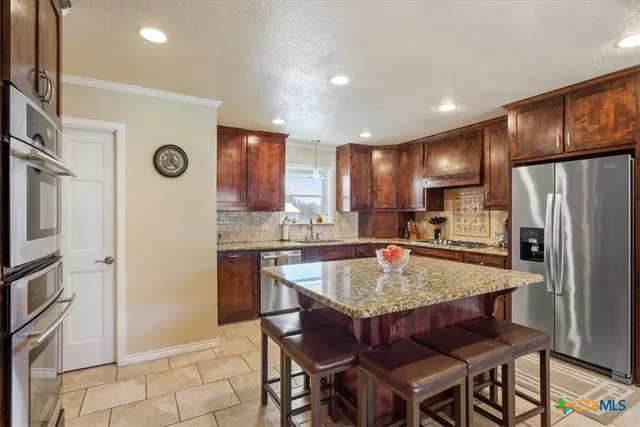 a bathroom with a granite countertop double vanity sink a mirror and a toilet