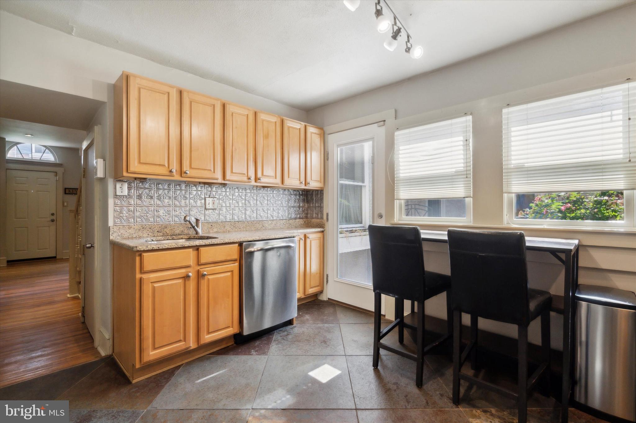 1640 Waverly Street Philadelphia, PA 19146 - Photo 6 of 16 a kitchen with stainless steel appliances granite countertop a table chairs sink and cabinets