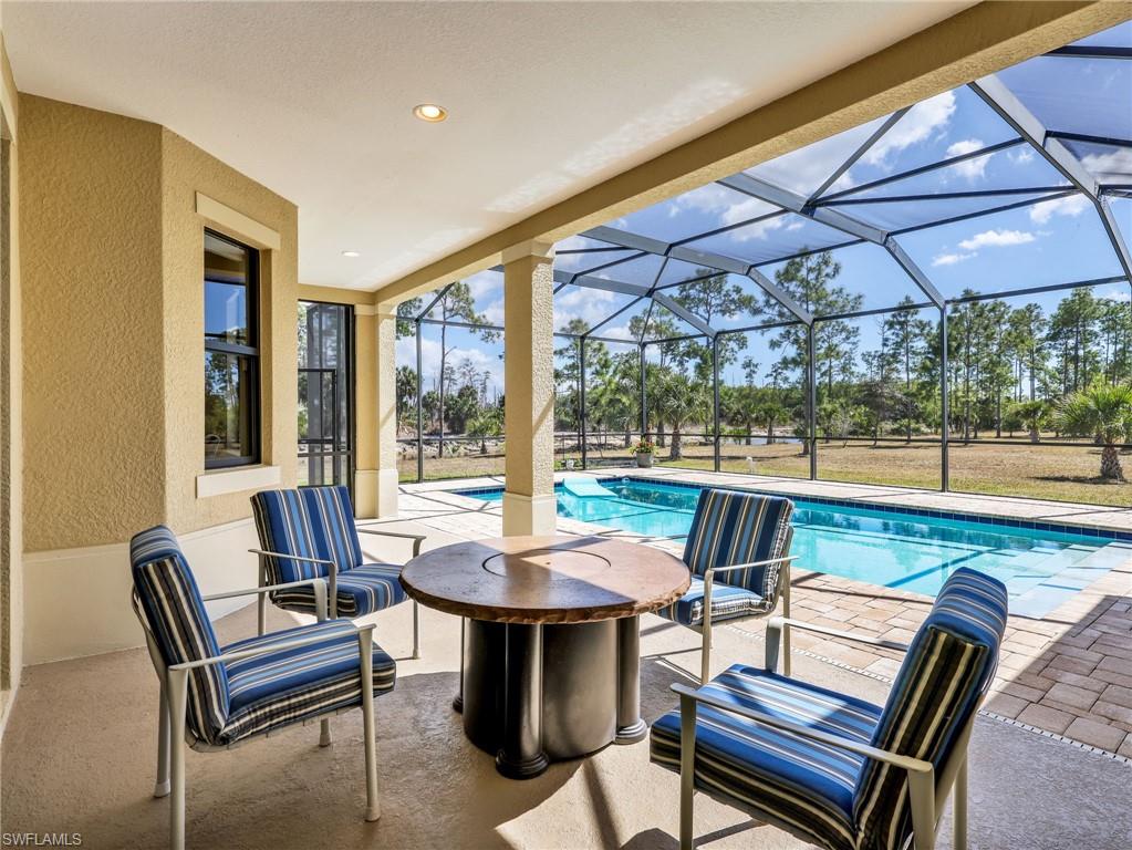 3160 27th Avenue Southwest Naples, FL 34117 - Photo 35 of 43 a outdoor sitting area with furniture and umbrella