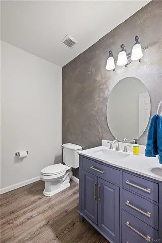 a spacious bathroom with a granite countertop sink a toilet and a mirror