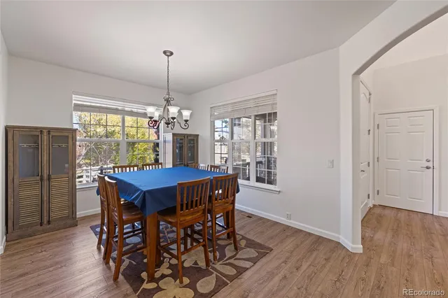 a kitchen with stainless steel appliances granite countertop a kitchen island hardwood floor sink stove dining table and chairs