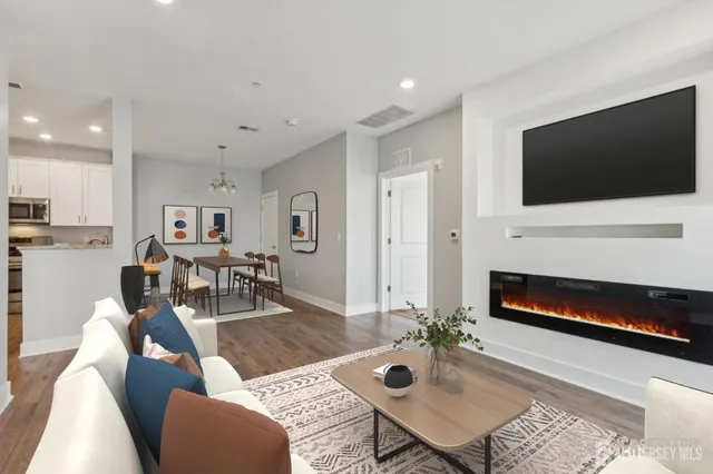 a living room with furniture a flat screen tv and a fireplace