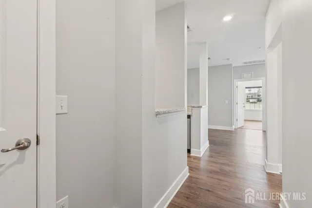 a view of a hallway with wooden floor