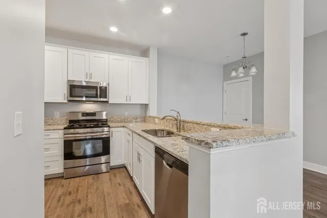 a kitchen with stainless steel appliances granite countertop a stove a sink and a microwave
