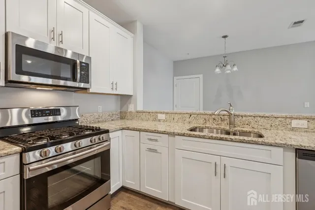 a kitchen with white cabinets and stainless steel appliances