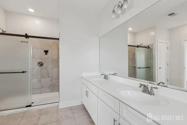 a bathroom with a double vanity sink mirror and shower