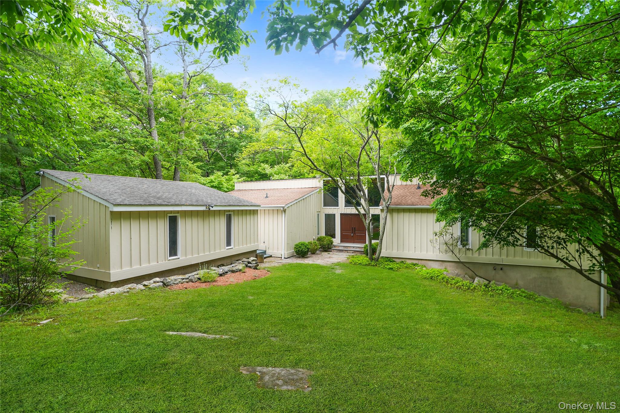 22 Peters Lane Pound Ridge, NY 10576 - Photo 2 of 43 Contemporary architectural style with board and batten siding, multiple rooflines, and a prominent front entrance featuring a double door with sidelights