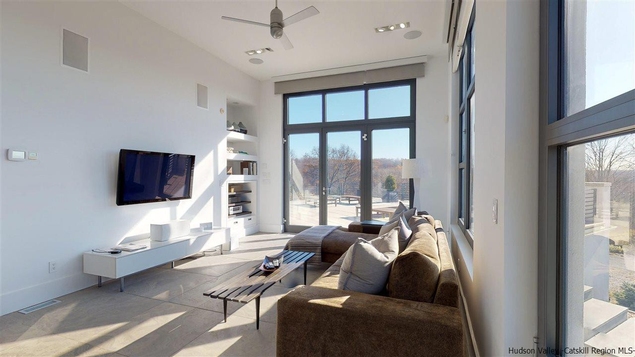 44 Willow Brook Road, Unit 3 799 000 Stanford, NY 12514 - Photo 18 of 18 a living room with furniture a floor to ceiling window and a flat screen tv