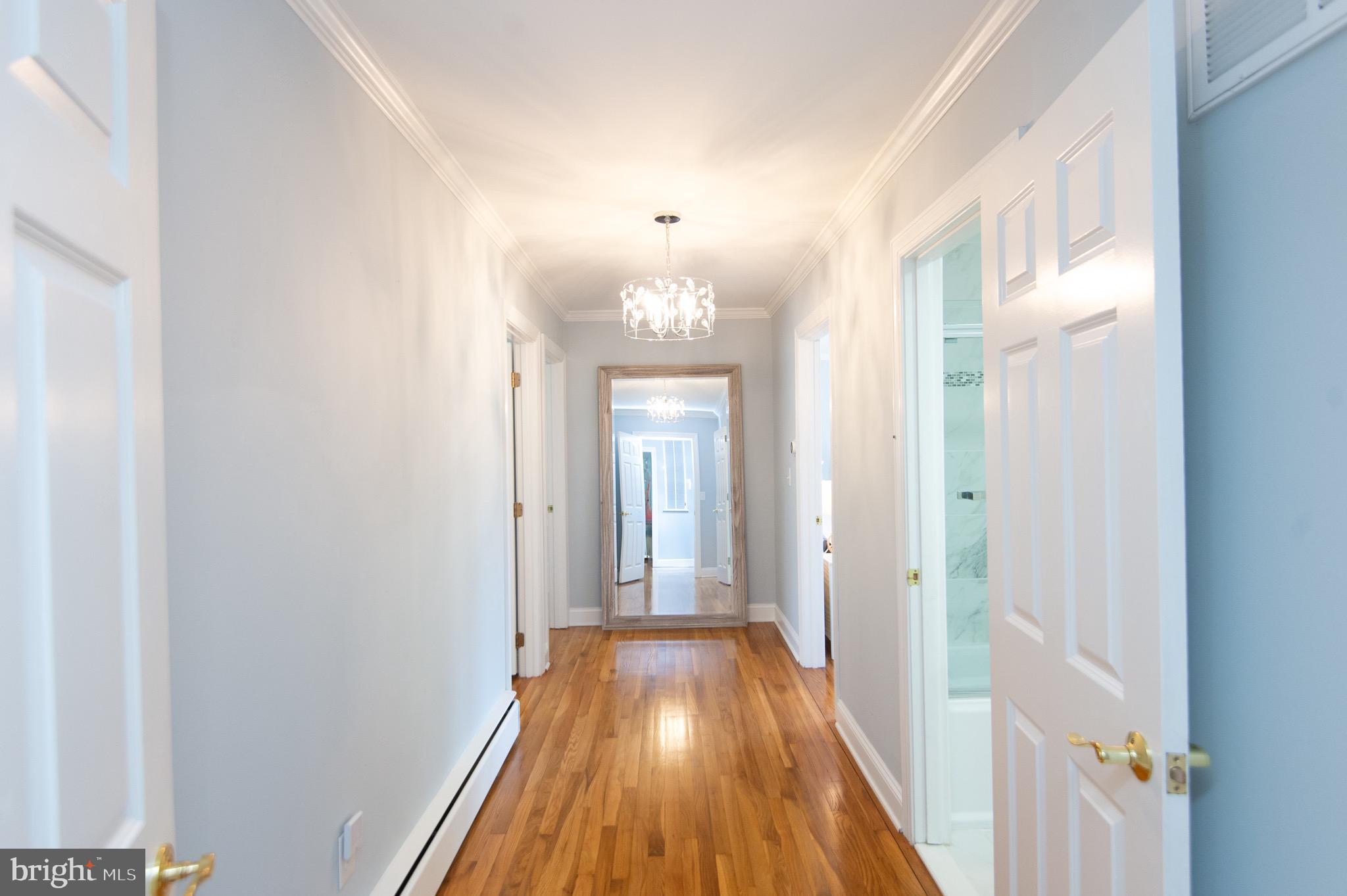 1417 School Street Cambridge, MD 21613 - Photo 32 of 73 a view of a hallway with wooden floor and a chandelier
