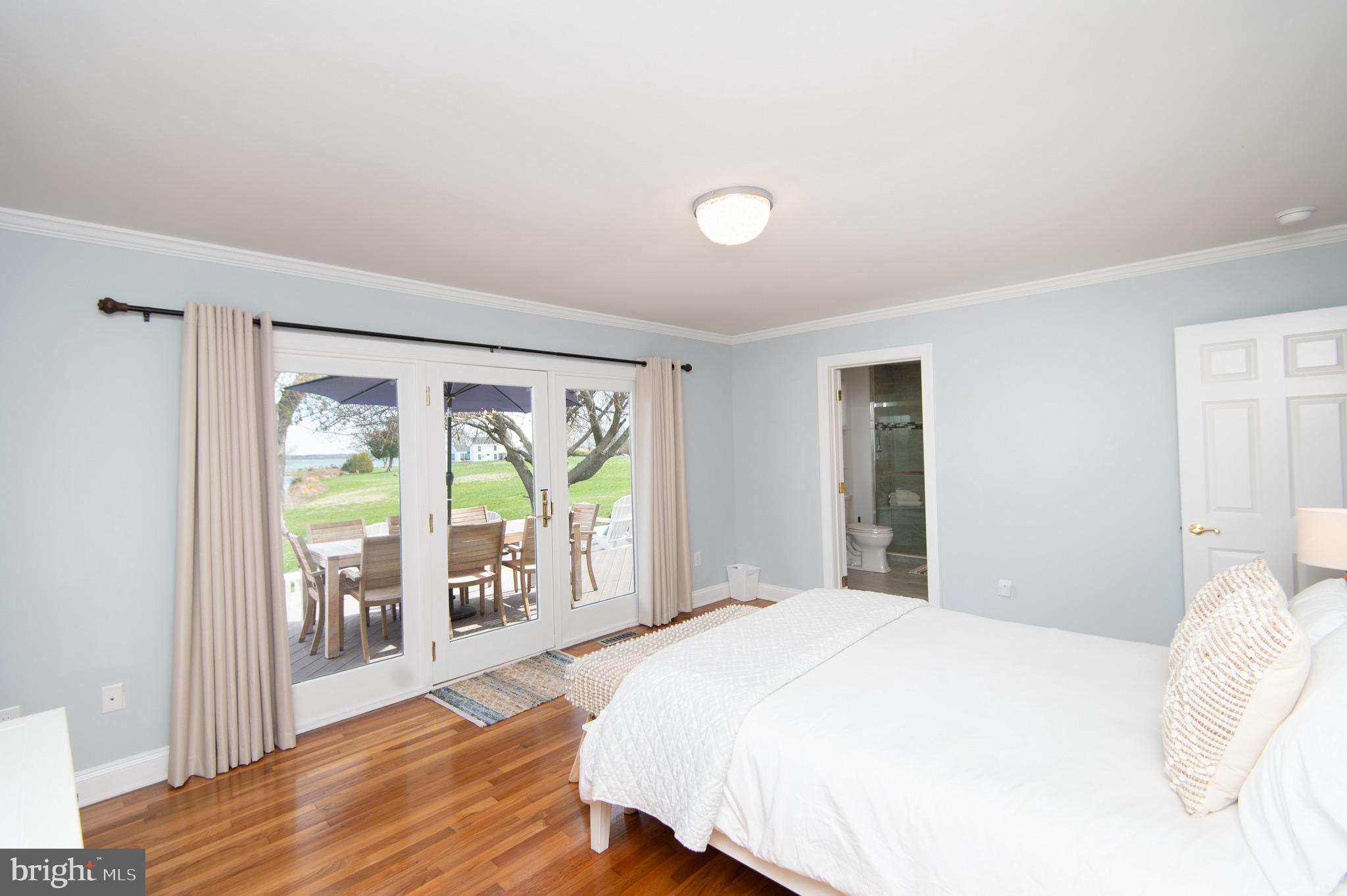 1417 School Street Cambridge, MD 21613 - Photo 36 of 73 a bedroom with a large window and wooden floor