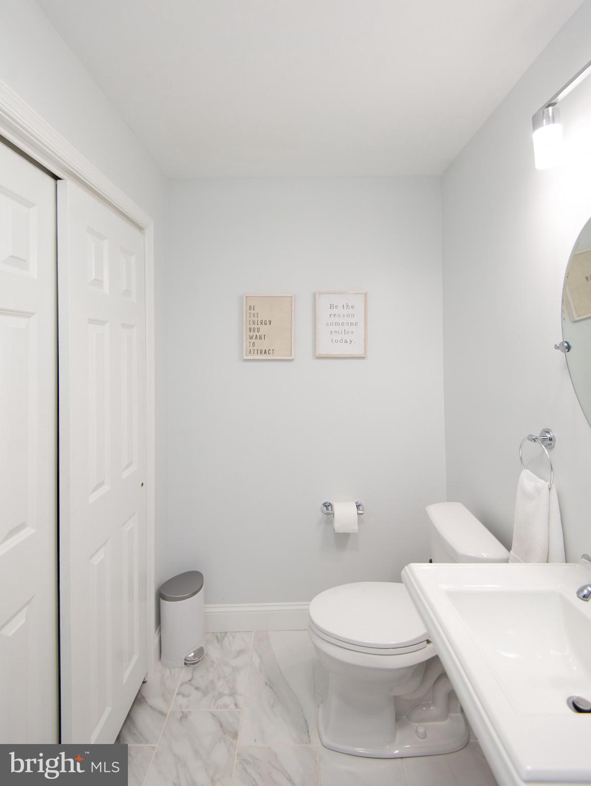 1417 School Street Cambridge, MD 21613 - Photo 45 of 73 a white toilet sitting next to a bathroom sink and vanity