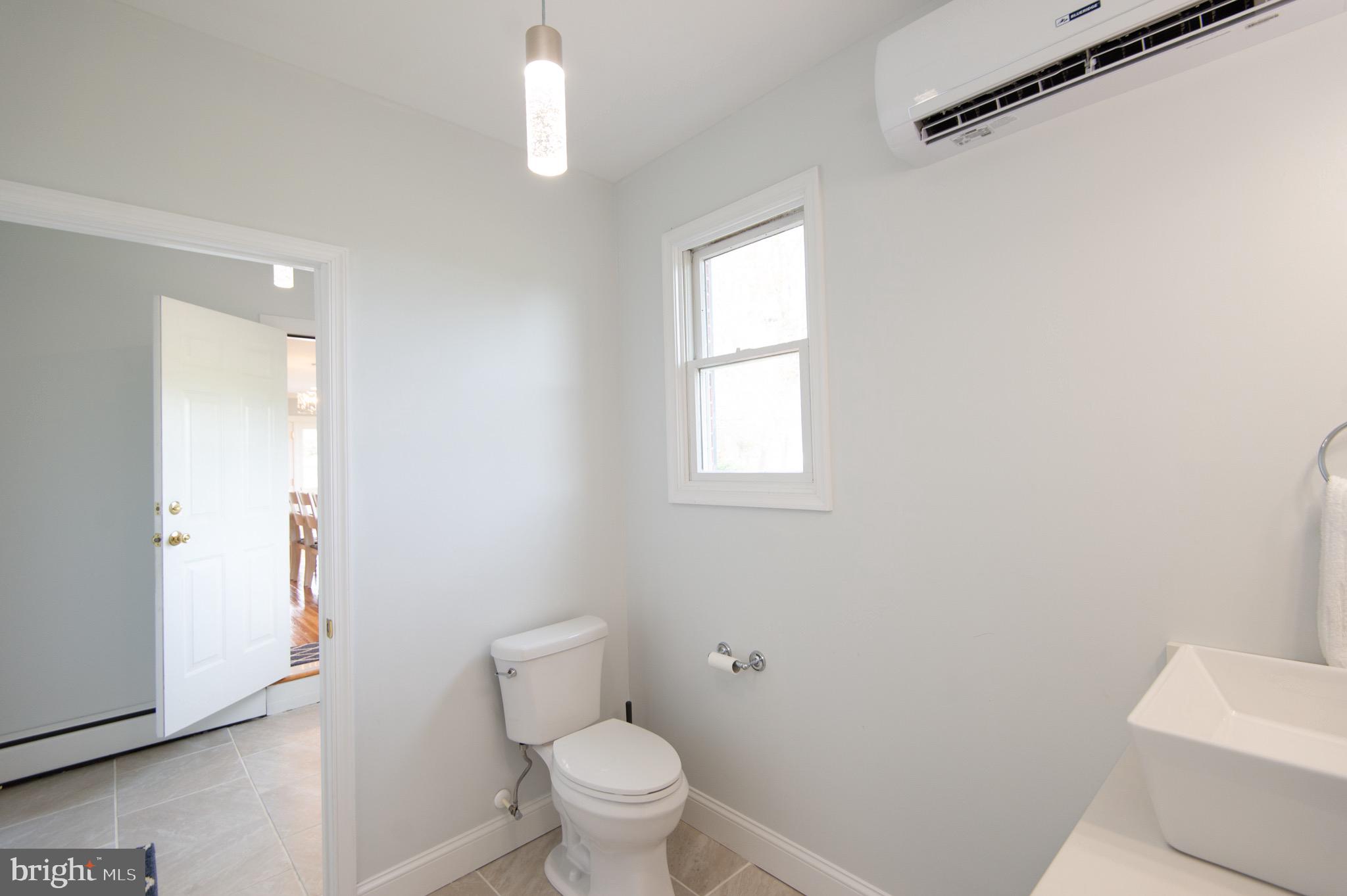 1417 School Street Cambridge, MD 21613 - Photo 49 of 73 a bathroom with a toilet a sink and a window