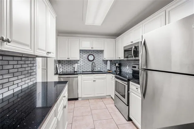 a living room with furniture kitchen view and a chandelier