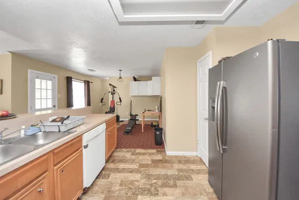 a large kitchen with a refrigerator and a sink