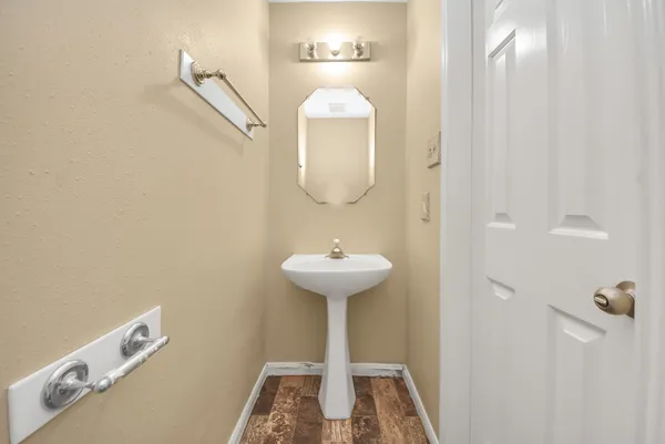 a bathroom with a sink a light fixture and a mirror
