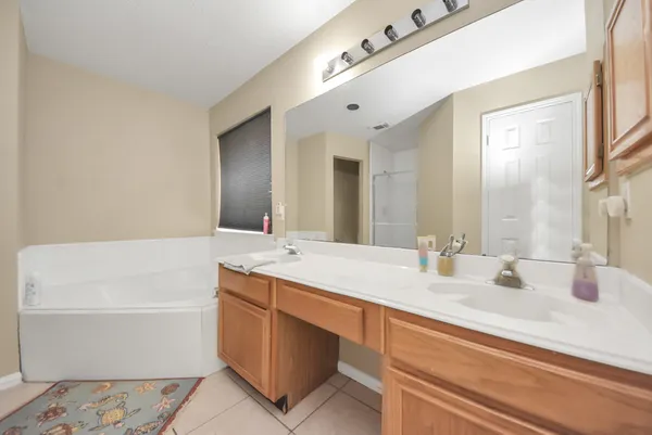 a bathroom with a tub sink and mirror